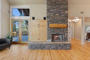 a fireplace in a living room with a stone wall at Lucy Lou 30 Day Minimum home in Bend