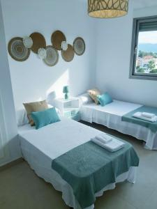 Cette chambre blanche dispose de 2 lits et d'une fenêtre. dans l'établissement Apartamento Aurora con terraza y vistas al mar, à Playa