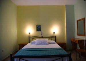 a small bedroom with a bed and a desk at Elena Apartments stoypa in Stoupa