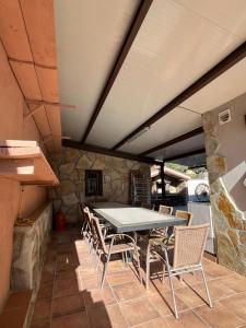 een tafel en stoelen op een patio met een stenen muur bij Casa Rural El Pinaron in Navaluenga