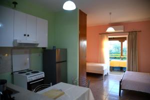 a kitchen with a stove and a kitchen with a table at Elena Apartments stoypa in Stoupa