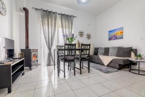 a living room with a couch and a table and chairs at Delfini Bliss 1 in Alexandroupoli