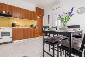 a kitchen with a table with chairs and a table with flowers at Delfini Bliss 1 in Alexandroupoli
