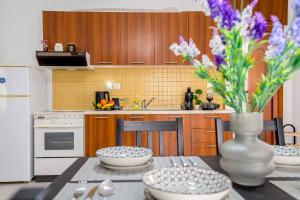 a kitchen with a table with a vase of flowers at Delfini Bliss 1 in Alexandroupoli