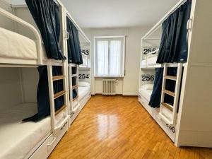 3 letti a castello in una camera con pavimento in legno di Bovisa Urban Garden a Milano