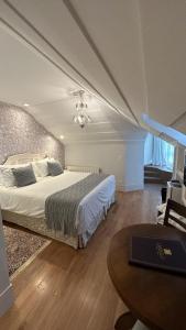 1 dormitorio con 1 cama grande y 1 mesa en Carballo Hotel & Spa en Campos do Jordão