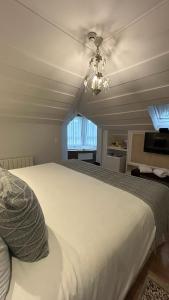 una camera da letto con un grande letto bianco e un soffitto di Carballo Hotel & Spa a Campos do Jordão
