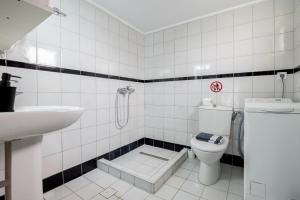a white bathroom with a toilet and a sink at Delfini Bliss 1 in Alexandroupoli