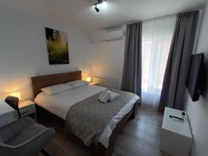 een kleine slaapkamer met een bed en een stoel bij Old Town Studio 2 apartment nr 2 in Baia Mare