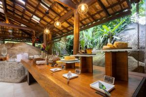 a restaurant with a long table with food on it at Pousada Naturalia in Abraão