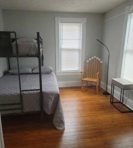 a bedroom with two bunk beds and a chair at 1895 meets 2023 Townhouse. in Hamilton