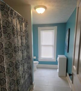 a bathroom with a toilet and a shower curtain at 1895 meets 2023 Townhouse. in Hamilton +13 photos
