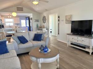 Una sala de estar con un sofá y un televisor. en UnCorked, en Oak Island