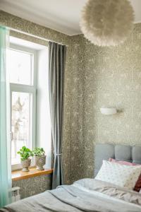 um quarto com uma cama, uma janela e um lustre em F.R.Kreutzwaldi 14-2 em Võru