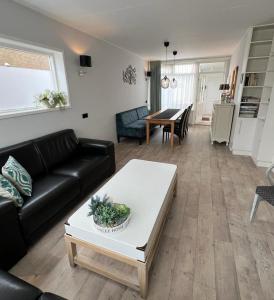 a living room with a couch and a table at Duinzee Texel in De Koog