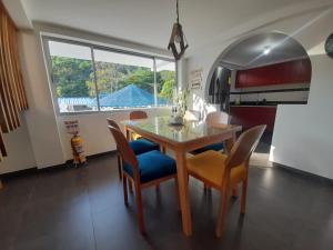 een eetkamer met een tafel en stoelen en een raam bij Casa Numbana in Norcasia