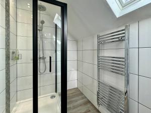 a bathroom with a shower and a glass door at Waterloo House - Urban Oasis Townhouse in Nottingham