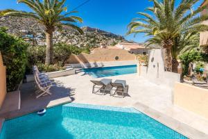 basen z palmami i willa w obiekcie Casa Veintiuno en Calp w mieście Calpe