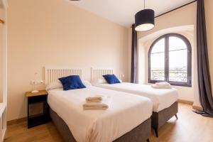 two beds in a room with a window at INSIDEHOME Ciudad de Avilés in Avilés