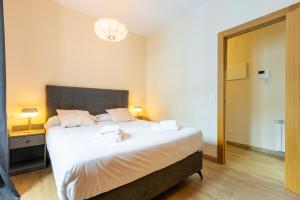 a bedroom with a large bed with two towels on it at InsideHome Ciudad de Avilés in Avilés