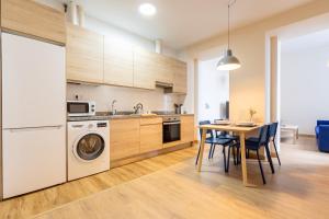 a kitchen and dining room with a table and a washing machine at InsideHome Ciudad de Avilés in Avilés