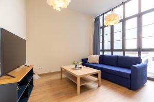 ein Wohnzimmer mit einem blauen Sofa und einem Tisch in der Unterkunft INSIDEHOME Ciudad de Avilés in Avilés