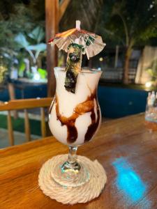 una bebida con un paraguas en una copa sobre una mesa en Sky Blue Hospedaje en Puerto Villamil