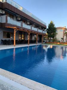 a large swimming pool in front of a building at akcayzeytin otel in Akcay