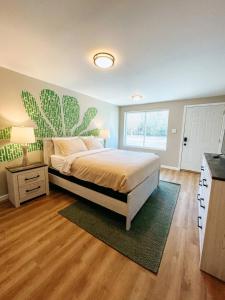a bedroom with a bed with a cactus painting on the wall at Mountain Explorer's Haven in Townsend