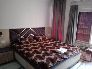 a bedroom with a bed with a comforter and a window at Ishita villa in Lucknow