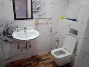 a bathroom with a white toilet and a sink at Ishita villa in Lucknow