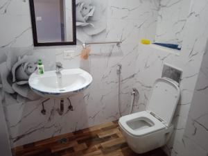 Un baño con un inodoro blanco y un lavabo. en Ishita villa, en Lucknow