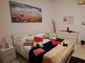 聖保羅灣城的住宿－The Palm Villa，一间卧室配有带枕头的床铺和绘画