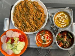 un plateau de nourriture avec différents types de nourriture dans l'établissement Royal Inn, à Jammu