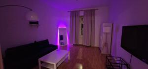 een paarse woonkamer met een bank en een tafel bij Weberknecht Apartments in Wenen
