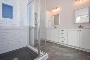 a white bathroom with a shower and white cabinets at Changes In Latitude in Dadeville +30 photos
