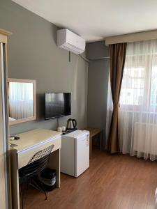 Zimmer mit einem Schreibtisch, einem Computer und einem Fenster in der Unterkunft akcayzeytin otel in Akçay
