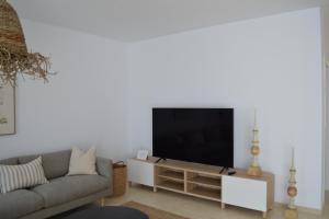 ein Wohnzimmer mit einem Sofa und einem Flachbild-TV in der Unterkunft Villa Tegala in Playa Blanca