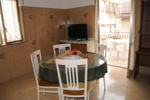ein Esszimmer mit einem Tisch, Stühlen und einem TV in der Unterkunft App. Biancavilla Catania II in Biancavilla