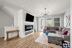 a living room with a couch and a tv at Uptown Avenue - Broomfield in Broomfield