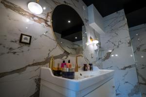a bathroom with a sink and a mirror at Appartement d'exception avec Jacuzzi in Villefranche-sur-Saône