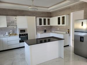een grote witte keuken met witte kasten en apparaten bij Samnica Guest House in Accra