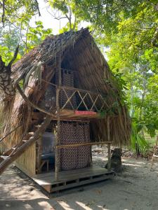 eine kleine Hütte mit einem Strohdach in der Unterkunft Eco-Camping Mango Feliz Rincón del Mar in San Onofre