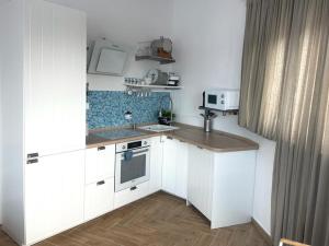una pequeña cocina con armarios blancos y fregadero en Apartment Mañana STINICA en Jablanac