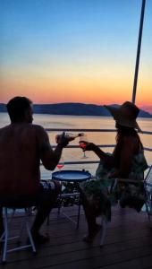 a man and a woman sitting on a deck watching the sunset at Apartment Mañana STINICA in Jablanac