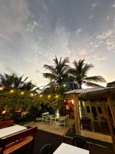 eine Terrasse mit einem Tisch, Stühlen und Palmen in der Unterkunft Sky Blue Hospedaje in Puerto Villamil