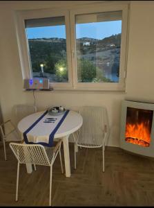 a table and chairs in a room with a fireplace at Apartment Mañana STINICA in Jablanac