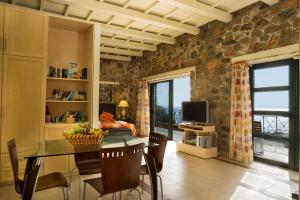 a dining room with a table and a television at Seaview villa Amphitriti with Private Pool, 20 min from Elafonissi beach in Chania