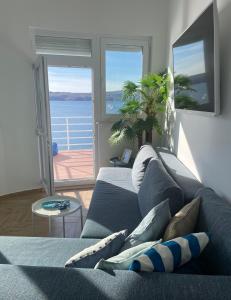 a blue couch in a living room with a view of the ocean at Apartment Mañana STINICA in Jablanac