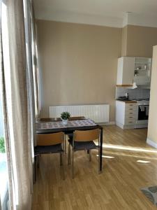 a table and chairs in a room with a kitchen at Rentalux Apartments at Nytorget in Sundsvall